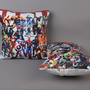 May include: Two decorative throw pillows with a superhero theme. The pillows are made of a soft, plush fabric and feature a colorful print of various superheroes.