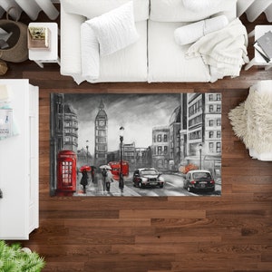 Puede incluir: Una pintura en blanco y negro de una escena callejera de Londres con el Big Ben, cabinas telefónicas rojas y autobuses de dos pisos. La pintura está sobre un fondo gris.