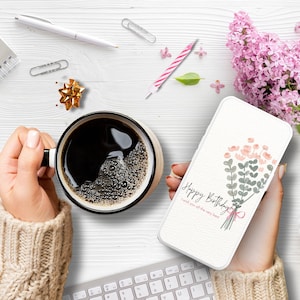 May include: A white phone case with a watercolor design of a bouquet of pink and green flowers. The text "Happy Birthday" and "I wish you all the very best" is printed on the case.