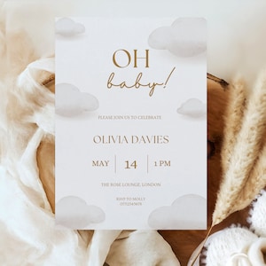 May include: A baby shower invitation with a white background and gold text. The invitation features a watercolor illustration of clouds and the text "OH baby!"  The invitation also includes the date, time, and location of the shower. RSVP information is included at the bottom.