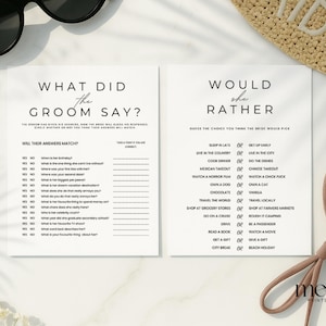 May include: Two white paper game cards with black text. One card reads "What Did the Groom Say?" and the other reads "Would She Rather?" The cards are for a wedding or bridal shower game. Sunglasses and a hat are in the background.