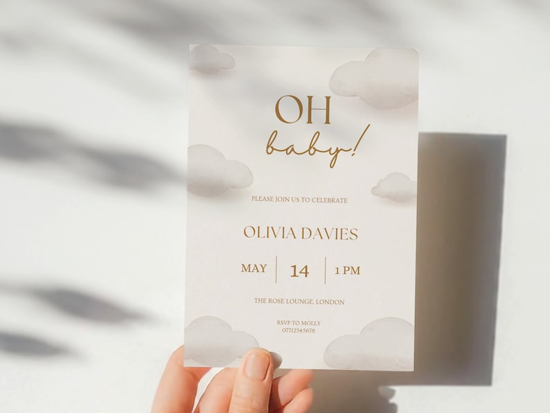 May include: A baby shower invitation with a cloud design and the text "OH baby!" in gold lettering. The invitation includes the name Olivia Davies, the date May 14, the time 1 PM, the location The Rose Lounge, London, and the RSVP information.