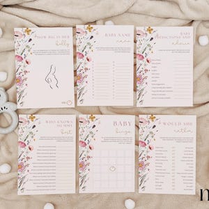 Op de afbeelding: Een set met printbare babyborrelspelkaarten met een bloemenontwerp. De kaarten bevatten spellen zoals "How Big is Her Belly", "Baby Name Game", "Predictions and Advice", "Who Knows Mommy Best", "Baby Bingo" en "Would She Rather".