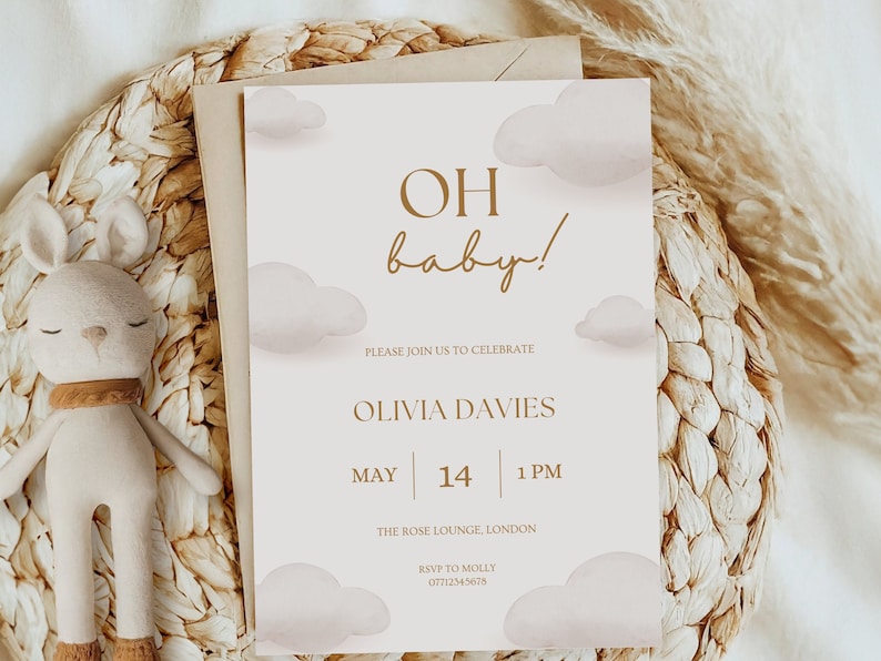 May include: A baby shower invitation with a light brown background and white clouds. The text reads "OH baby!" in a brown script font. The invitation includes the name Olivia Davies, the date May 14, the time 1 PM, the location The Rose Lounge London, and the RSVP information.