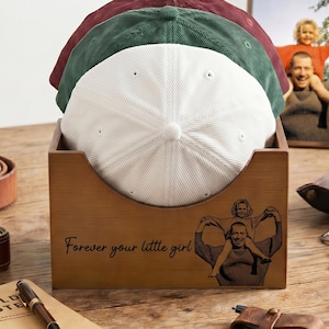 May include: Three corduroy baseball caps in white, green, and burgundy are displayed in a wooden box. The box has a photo of a father and child and the text "Forever your little girl". Other accessories are on the wooden table.