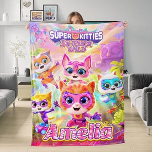 May include: A colorful blanket featuring the text "Disney Jr. Super Kitties Su-Purr Wild" and the name "Amelia." The blanket showcases cartoon kittens in various colors, including orange, pink, and purple, set against a vibrant background.