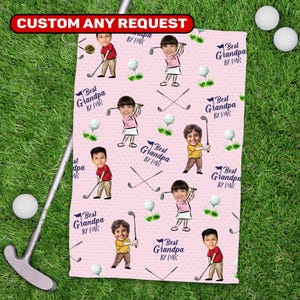 May include: Pink golf towel with a repeating pattern of cartoon golfers, golf balls, and crossed golf clubs. Text reads "Best Grandpa BY PAR" and "CUSTOM ANY REQUEST". The towel is on a green grass background.