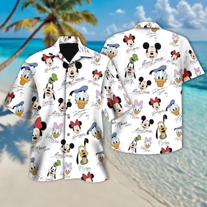 May include: White button-up shirt with a short sleeve featuring a repeating pattern of Mickey Mouse, Minnie Mouse, Donald Duck, Goofy, and Pluto characters. The characters are in color and have their names written in black cursive.