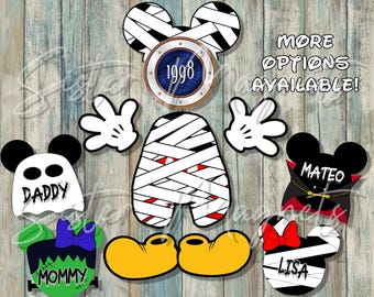 May include: A collection of Halloween-themed character magnets featuring a mummy-wrapped mouse head with the year 1998, white gloves, yellow shoes, a ghost labelled DADDY, a vampire labelled MATEO, a green monster labelled MOMMY, and a mummy labelled LISA.