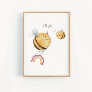 May include: A framed print of a watercolor illustration featuring two cartoon bees flying over a rainbow. The larger bee is yellow with brown stripes and is flying over a rainbow with pink, orange, and yellow stripes. The smaller bee is yellow with brown stripes and is flying behind the larger bee.
