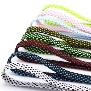 May include: A collection of flat shoelaces featuring a two-tone woven mesh pattern. The laces are available in various color combinations including white with blue, black with blue, black with red, black with green, black with yellow, and white with pink.