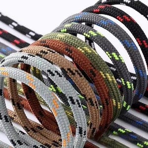 May include: A collection of braided cords arranged in a series of loops. The cords feature various solid base colors including light gray, brown, olive green, dark gray, and black, each accented with small, repeating diagonal dashes of contrasting colors.