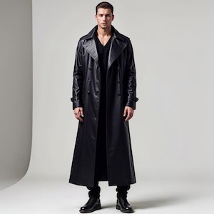 May include: A full-length black leather trench coat with a double-breasted design. The coat features a notched collar, button closures, and a long, flowing silhouette. The model is wearing a black shirt and black pants.