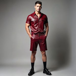 May include: A burgundy leather shirt and shorts set. The short-sleeved shirt has two chest pockets and a button-down front. The shorts have a belt and pockets. The outfit is paired with black socks and shoes. The Leather Crafter logo is visible.