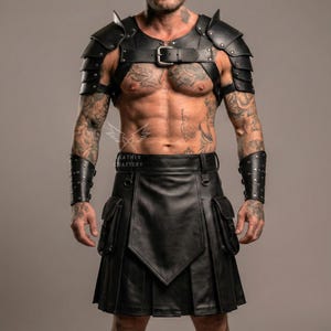 Könnte beinhalten: Schwarzer Lederkilt mit Taschen, kombiniert mit passender Schulterrüstung und Handgelenkmanschetten. Die Rüstung hat geschichtete Platten und Schnallenverschlüsse. Der Kilt hat ein plissiertes Design und eine Frontklappe.