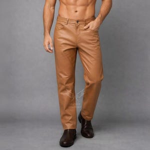 May include: Tan leather trousers with a classic five-pocket design. The trousers have a straight leg cut and a button and zip closure. The leather has a smooth texture and a slight sheen. The trousers are paired with brown leather shoes.