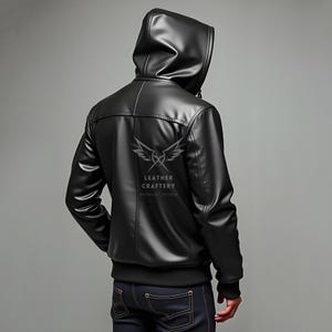 May include: Black leather jacket with a zippered hood. The jacket has a  "Leather Craftery" logo on the back.
