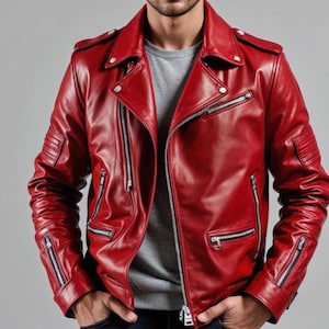 Op de afbeelding: Een felrode leren jas in klassieke bikerstijl. Voorzien van een asymmetrische ritssluiting, meerdere ritszakken en gewatteerde details op de schouders en mouwen. De jas heeft een reverskraag en zilverkleurige hardware.