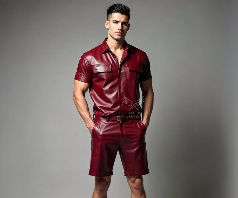 May include: A burgundy leather shirt and shorts set. The short-sleeved shirt has two chest pockets and a button-down front. The shorts have a matching belt. The set is worn by a person.