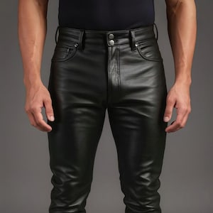May include: Close-up of black leather trousers with a classic five-pocket design. The trousers have a button and zip closure and are made of a smooth, shiny leather material. The trousers are tailored with a slim fit.