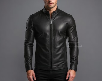 May include: A black leather jacket with a stand-up collar and a full-length zipper. The jacket has long sleeves and a tailored fit. The model is wearing the jacket. The jacket is a classic style.