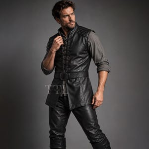 May include: A black leather vest featuring a high collar, quilted shoulder panels, and a front lace-up closure. The vest is cinched at the waist with a matching black leather belt with a buckle, worn over a grey long-sleeved shirt and black leather pants.