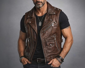 May include: Brown leather vest with multiple zippered pockets and a notched collar. The vest has a classic biker style with a belt at the waist and silver hardware. The vest is worn over a black t-shirt.