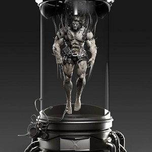 Op de afbeelding: Een gespierd figuur met klauwen hangt in een doorzichtige glazen buis. Het figuur is verbonden met draden en buizen. De buis is ingekapseld in een metalen frame met een zwarte basis.
