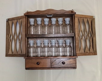 1970's Beautiful Wood Spice Cabinet. 12 Clear Glass Spice Jars And Clear/Frosted Plastic Lids. Two Magnetic Scroll Cut Doors And Two Drawers