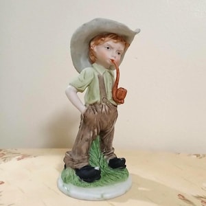 Figurine Depicting A Boy Street Urchin Smoking A Long Pipe By Himark Designed Giftware (1980-1991). Bisque Porcelain Figurine #20-5440