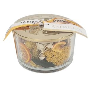 May include: A glass jar filled with dried orange slices, flowers, and leaves. The jar has a gold lid with a decorative cutout design. The lid has a label that reads "ANDALUCIA".