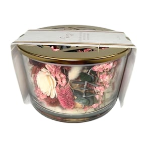 May include: A glass jar filled with dried flowers and greenery, with a gold metal lid and a decorative cutout design. The jar is surrounded by a clear plastic packaging.