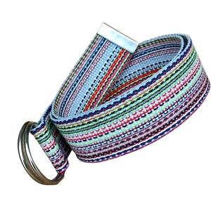 May include: A woven fabric belt featuring a multi-colored striped pattern in shades of light blue, red, yellow, green, and white. The belt includes a silver-toned metal tip at one end and two circular silver-toned metal rings at the other end.