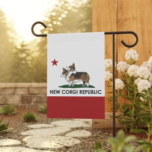 May include: A garden flag featuring a design with a red star, two corgis, and the text "NEW CORGI REPUBLIC" on a white background with a red stripe at the bottom. The flag is displayed outdoors.