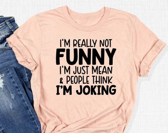 May include: A peach-colored t-shirt with black text that reads "I'm really not funny I'm just mean & people think I'm joking".
