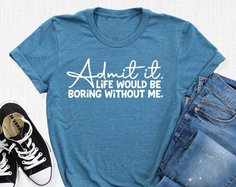 May include: A teal blue t-shirt with the text "Admit it. Life would be boring without me." printed in white.