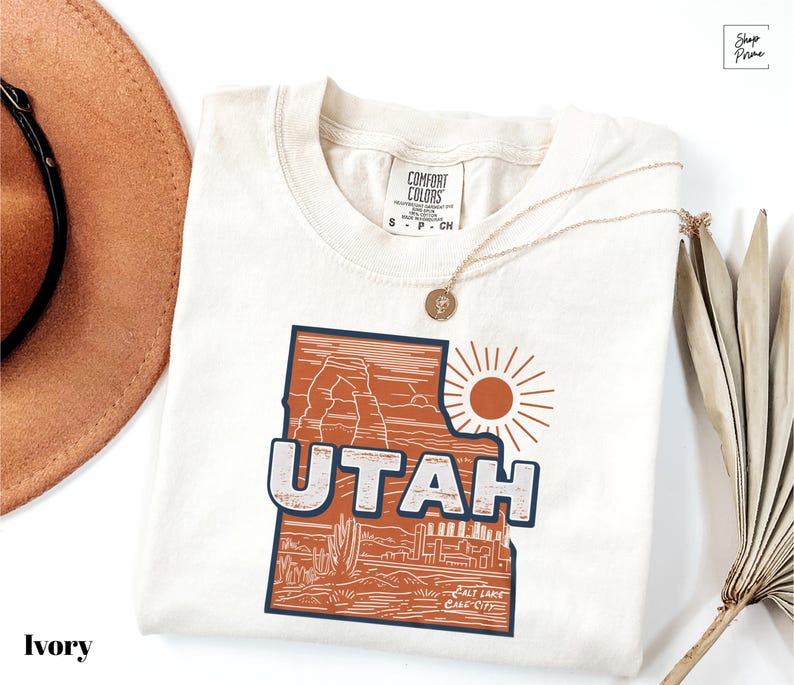 a hat, sunglasses, and t - shirt on a white surface