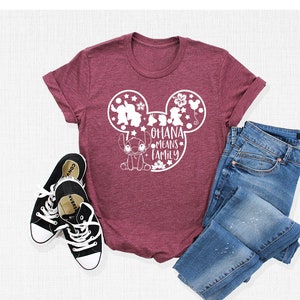 Może przedstawiać: Bordowy t-shirt z białą sylwetką Myszki Miki przedstawiającą Stitch i napis "Ohana means family".