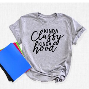 May include: Gray t-shirt with black text that reads "Kinda Classy Kinda Hood".