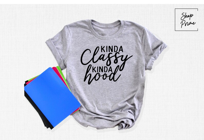May include: Gray t-shirt with black text that reads "Kinda Classy Kinda Hood".