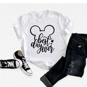 May include: White t-shirt with a black Mickey Mouse ears design and the text "best day ever" in black script.