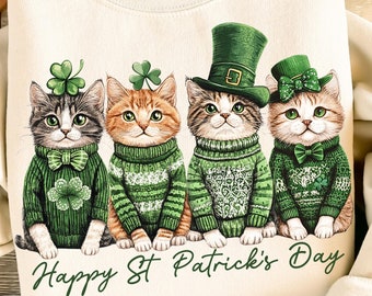 May include: A beige sweatshirt with a graphic of four cats wearing green sweaters and hats. The cats are lined up and the text "Happy St. Patrick's Day" is printed below them.