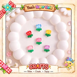 May include: Six small, translucent, flower-shaped resin charms in blue, red, yellow, pink, light pink, and purple, each with a green stem and leaf base. The text Yua's Super Cute and CRAFTS - Relax - Create - Enjoy is visible.
