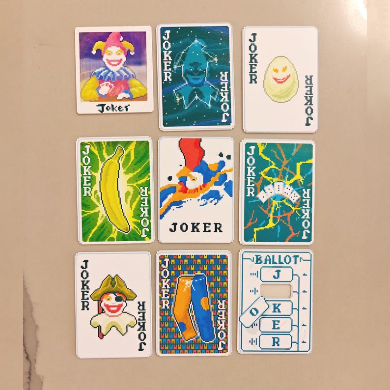 May include: Nine playing cards with the word "Joker" on them. The cards feature various colorful illustrations, including a jester, a banana, and a ballot. The cards are arranged in a grid pattern.