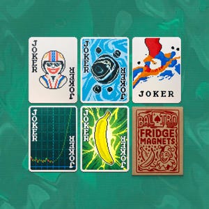 May include: A collection of six playing cards with pixelated designs. The cards feature images of a racer, a planet, abstract art, a graph, a banana, and a fridge magnet set. The word "JOKER" is printed on several cards.