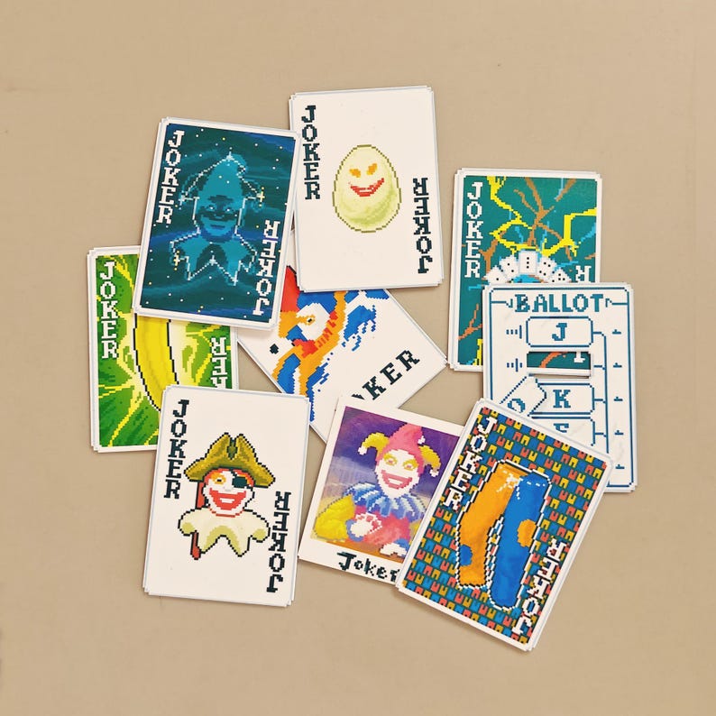 May include: A collection of pixelated playing cards featuring various joker designs. The cards display colorful illustrations of jesters, clowns, and abstract patterns. Each card has the word "JOKER" printed on it.
