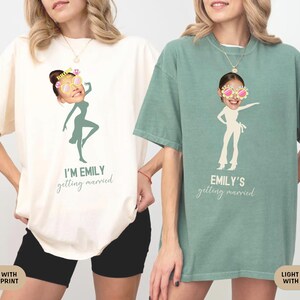 May include: Two white t-shirts with a green print. One shirt says "I'm Emily getting married" and features a silhouette of a woman with sunglasses. The other shirt says "Emily's getting married" and features a silhouette of a woman with sunglasses.