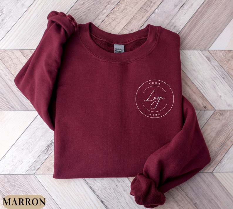 May include: Maroon sweatshirt with a white circle logo that says "Your Logo Here" on the left chest.