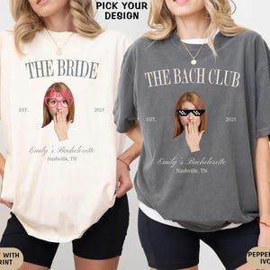 May include: Two t-shirts with different designs. The ivory shirt has the text "The Bride" with a woman wearing pink sunglasses and the text "Emily's Bachelorette Nashville, TN" The gray shirt has the text "The Bach Club" with a woman wearing pixelated sunglasses and the text "Emily's Bachelorette Nashville, TN".
