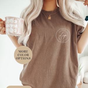 May include: A brown t-shirt with the text "Your Logo Here" in a circle on the front. The shirt is made of a soft, comfortable material and has a relaxed fit. More color options are available.